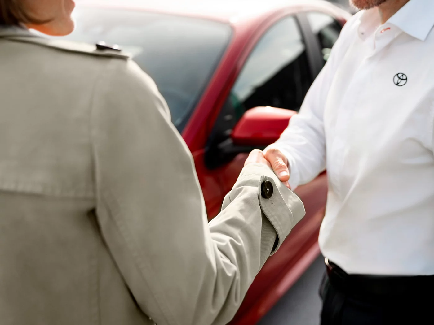 Beratung: Handschlag, Toyota im Hintergrund
